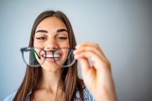 happy young lady looking at her new glasses